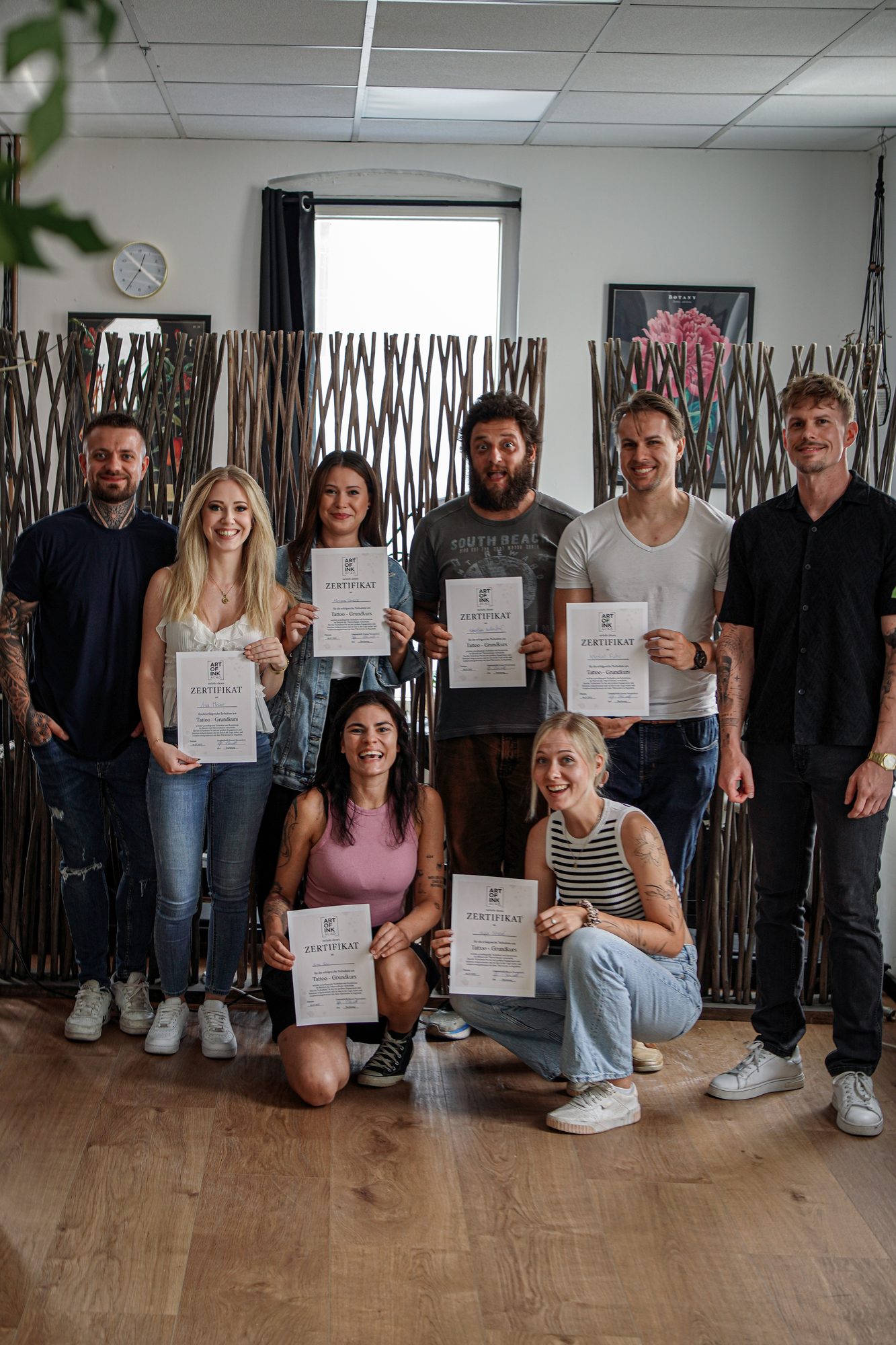 Teilnehmer des Tattoo-Grundkurses mit ihren Abschlusszertifikaten im Studio Backnang